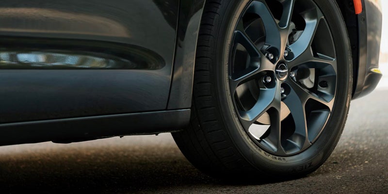 Close-up of dark grey multi-spoke wheel on black car