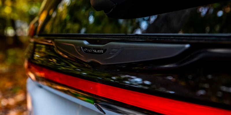 Close-up of Chrysler logo and red light bar on black car
