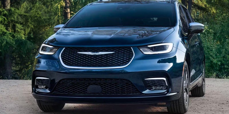 Front view of dark blue Chrysler minivan parked outdoors