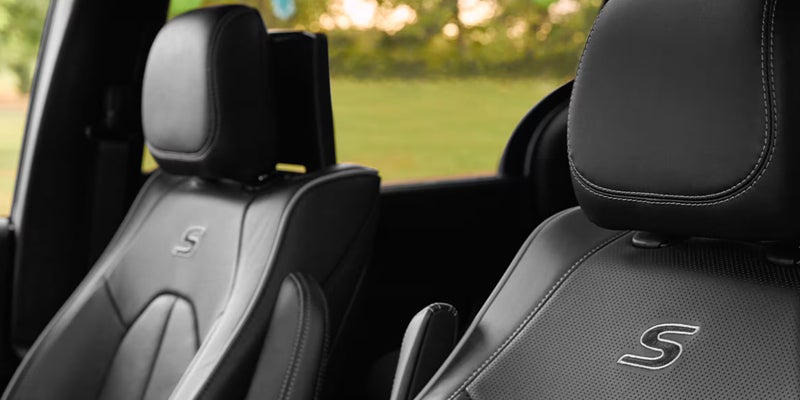 Black leather vehicle seats with white stitching and "S" trim logo