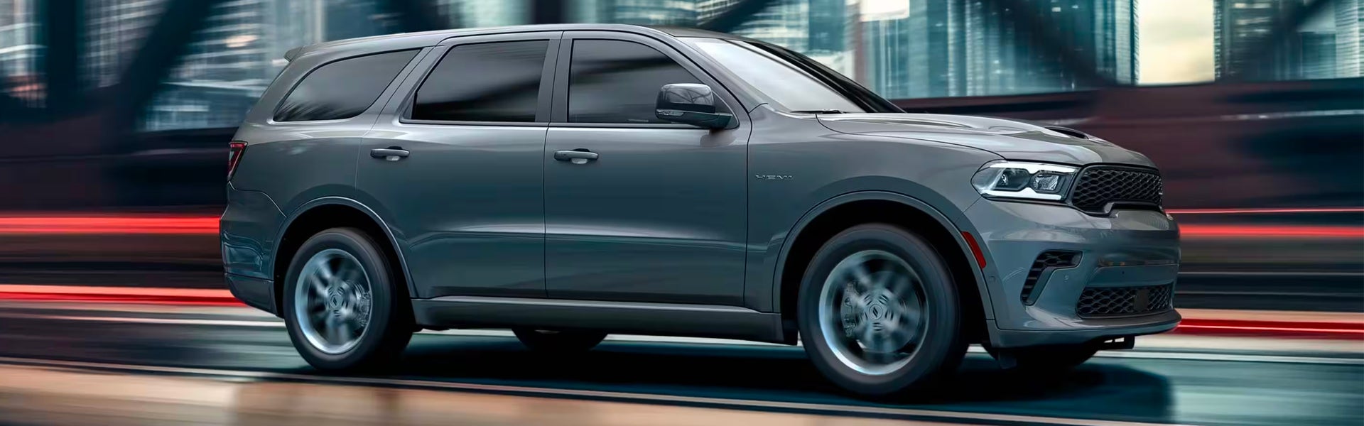 Grey Dodge Durango SUV driving quickly through a blurred city street