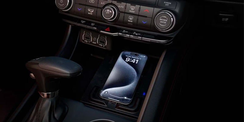 Close-up of a phone on a wireless charging pad in a car console