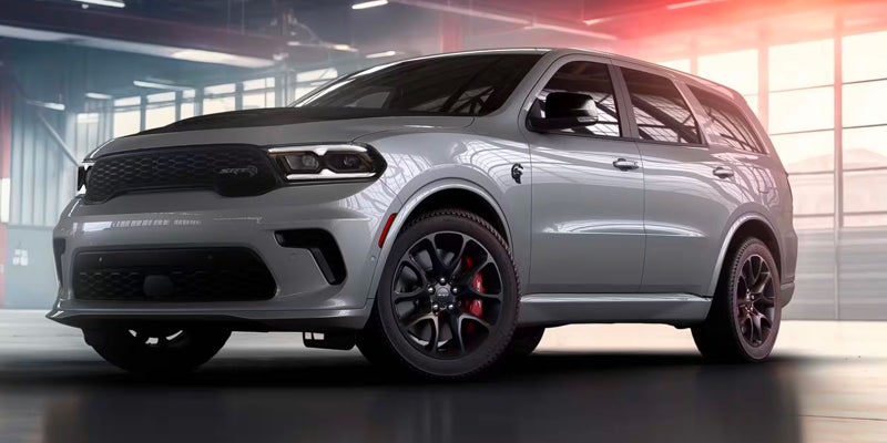 A grey Dodge Durango SRT is parked indoors with a modern backdrop