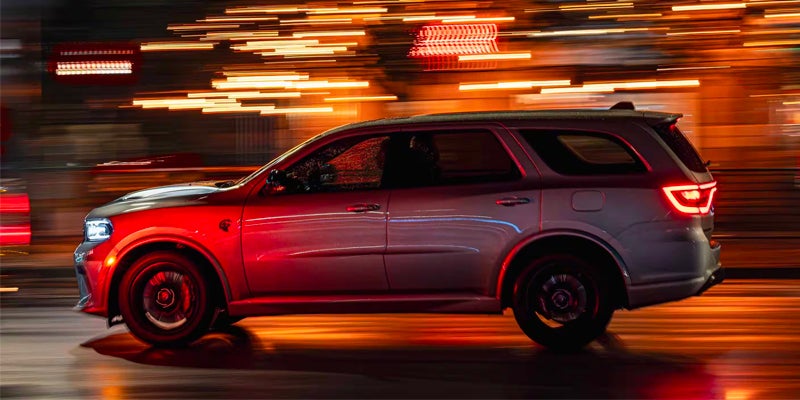A silver Dodge Durango SRT driving at night with light streaks