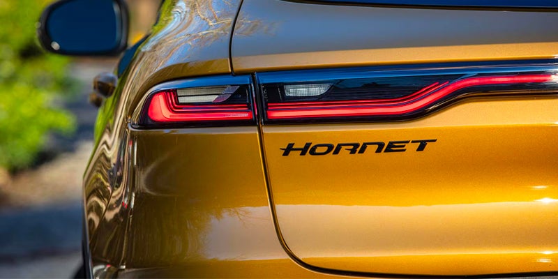 Close-up of the Dodge Hornet badge and taillight on a yellow vehicle