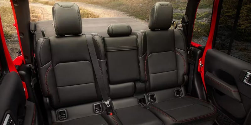 Black leather rear seats of a Jeep with red stitching