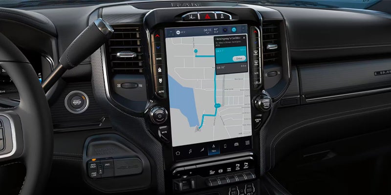 A large, vertically-oriented touchscreen in a car's dashboard displays a navigation map with a route highlighted in blue.
